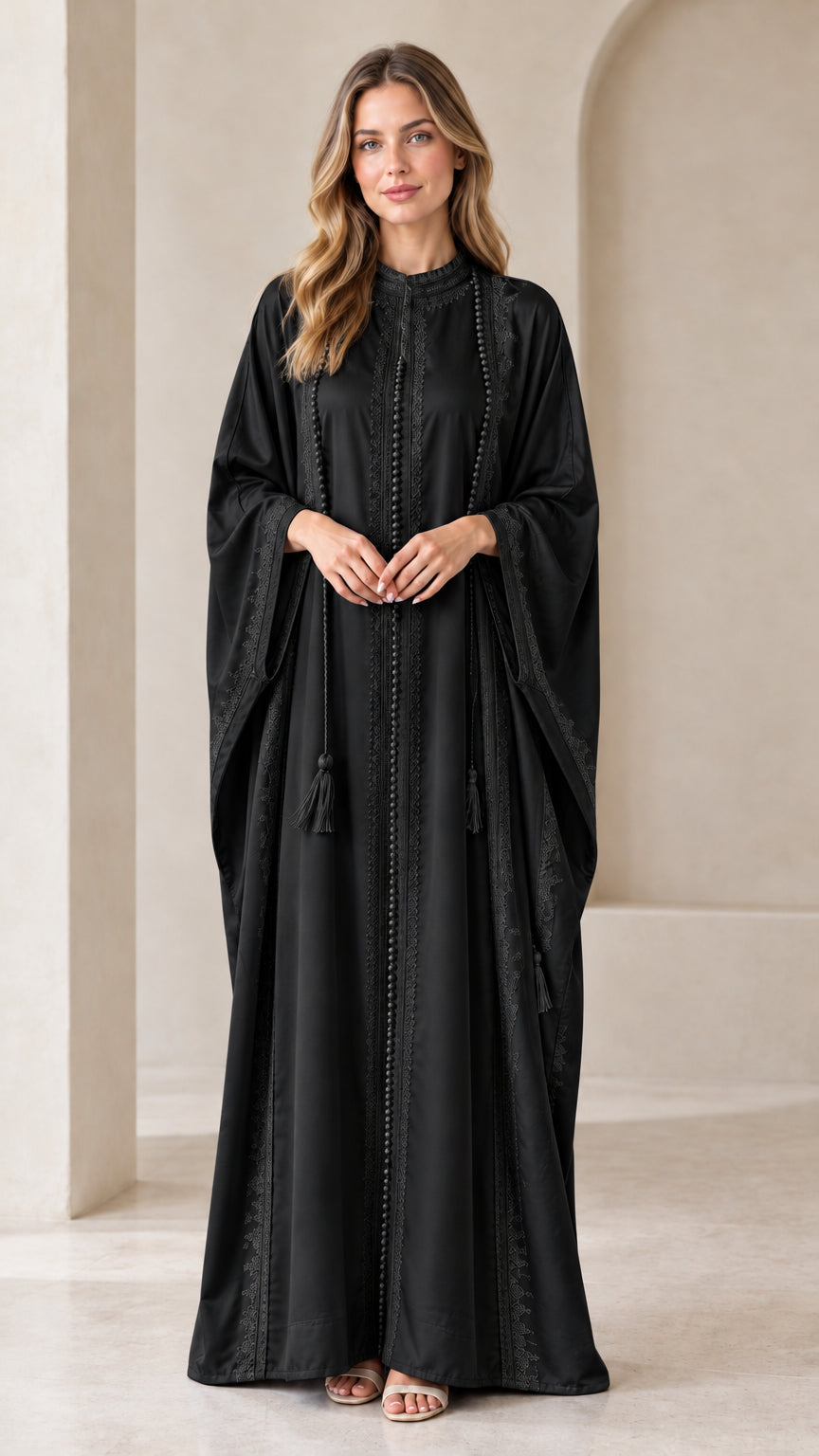 Front view of woman wearing Black embroidered batwing kaftan maxi dress with tassels