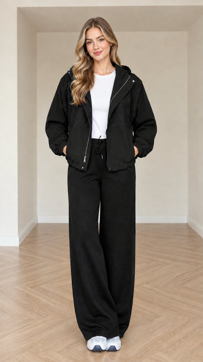 Model wearing black women's hooded jacket and wide-leg matching set
