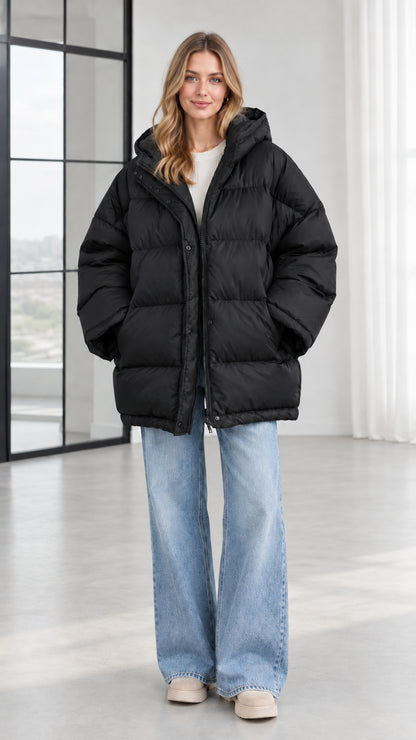 Front view of model wearing black oversized hooded puffer jacket