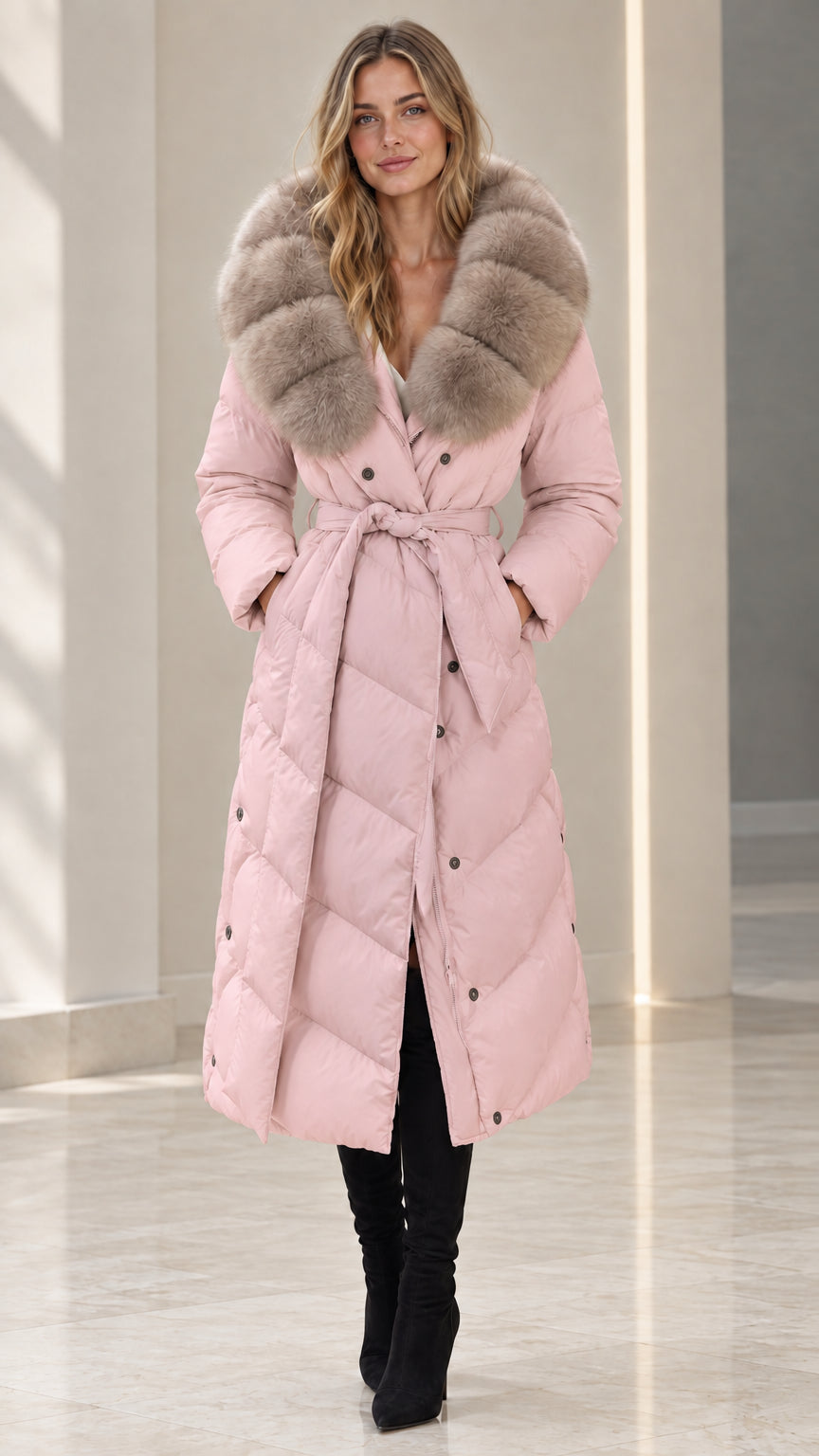 Front full-length view of woman wearing dusty pink belted maxi puffer coat with plush fur collar