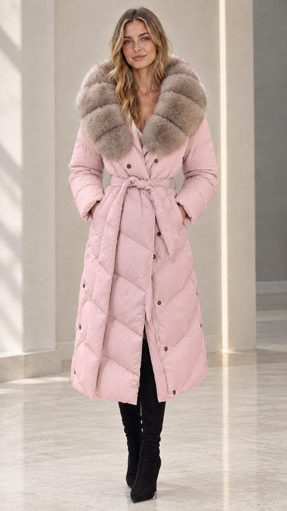 Front full-length view of woman wearing dusty pink belted maxi puffer coat with plush fur collar