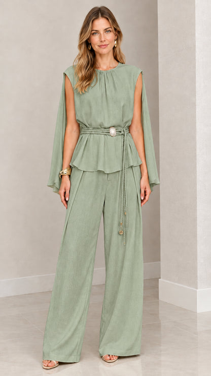 Front view of woman wearing sage green cape sleeve peplum top and wide leg pants set