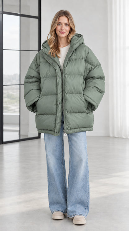Front view of model wearing sage green oversized hooded puffer jacket