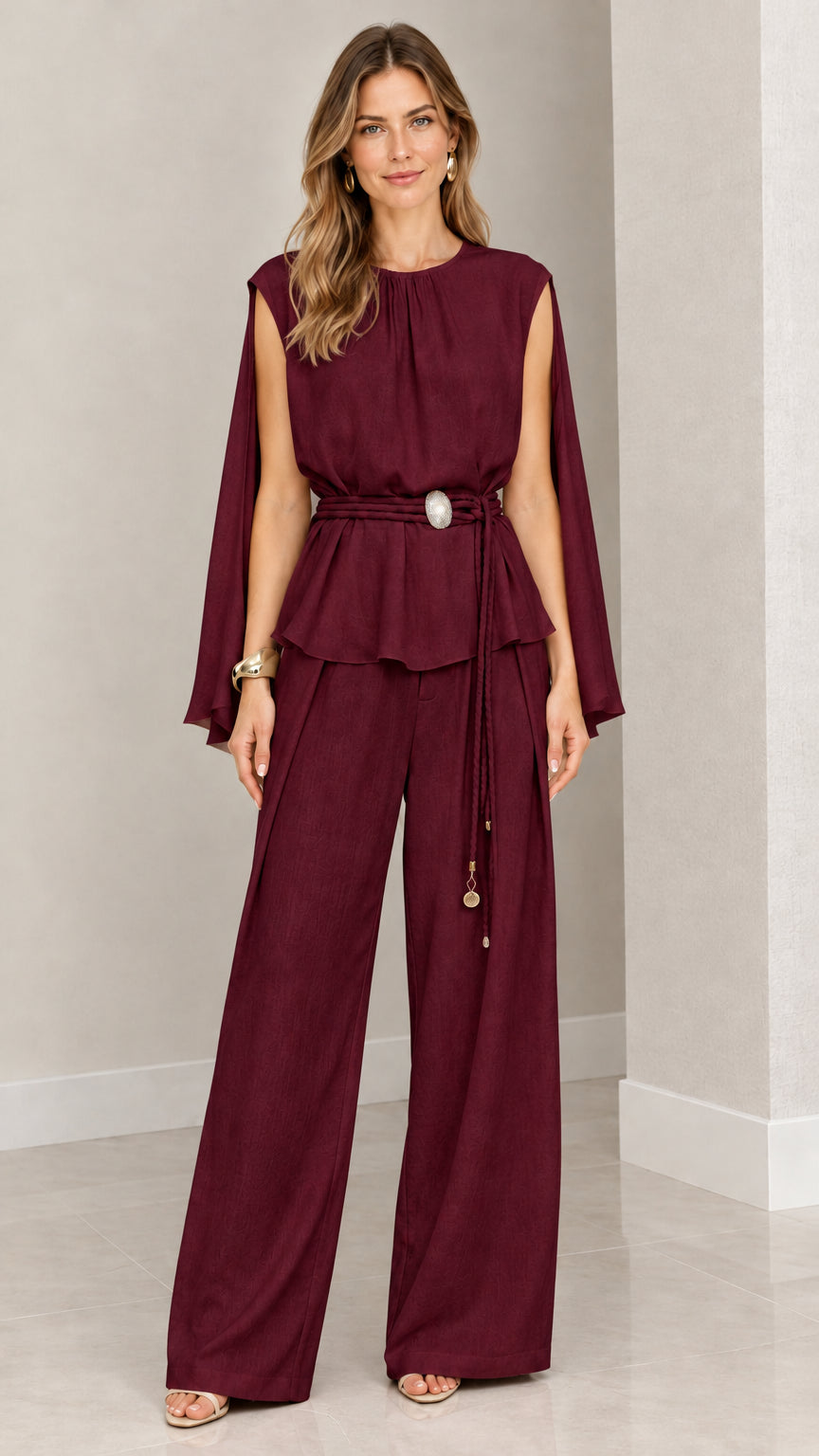 Front view of woman wearing burgundy cape sleeve peplum top and wide leg pants set
