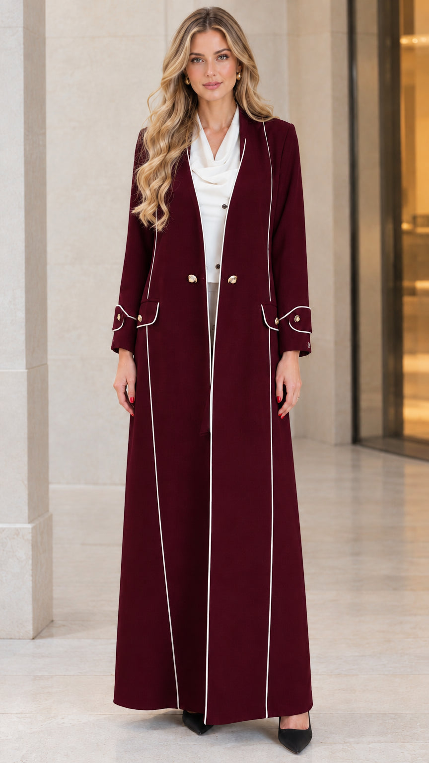 Front view of woman wearing burgundy wine red longline duster coat with white piping
