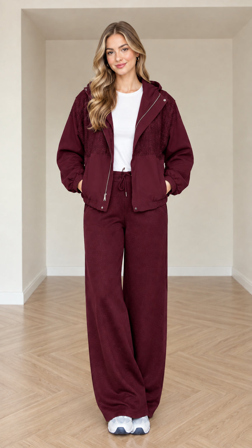 Model wearing burgundy women's hooded tracksuit set with wide-leg pants