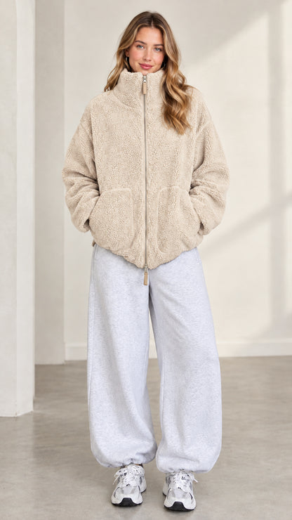 Front view of model wearing beige cream plush teddy fleece jacket